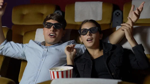 3Dメガネで映画を見ている映画館の男と女 画面を見て興味を持ちポップコーンを食べ — ストック写真
