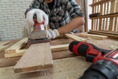 Marangoz atölyede ahşap işçiliği yapıyor. İnşaat malzemesi ya da ahşap mobilya üretiyor. Genç Asyalı marangoz zanaat için profesyonel araçlar kullanır. DIY üreticisi ve marangozluk konsepti.