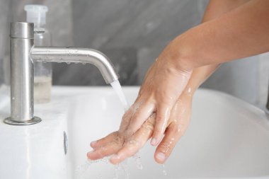 Coronavirus hastalığının önlenmesi için ellerini yıka. 2019 veya COVID-19. İnsanlar virüs enfeksiyonunu temizlemek için lavaboda ellerini yıkıyor..