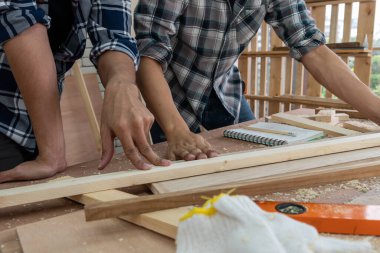 Marangoz atölyede ahşap işçiliği yapıyor. İnşaat malzemesi ya da ahşap mobilya üretiyor. Genç Asyalı marangoz zanaat için profesyonel araçlar kullanır. DIY üreticisi ve marangozluk konsepti.
