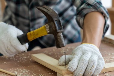 Marangoz atölyede ahşap işçiliği yapıyor. İnşaat malzemesi ya da ahşap mobilya üretiyor. Genç Asyalı marangoz zanaat için profesyonel araçlar kullanır. DIY üreticisi ve marangozluk konsepti.