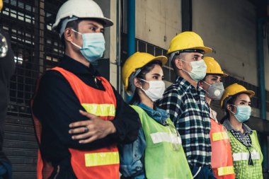 Yüz maskesi olan fabrika işçileri Corona Virüs Hastalığı 2019 veya COVID-19 salgınlarından korunuyor..