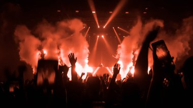 Mutlu insanlar gece kulübü DJ parti konserinde dans eder ve sahnede DJ 'den elektronik dans müziği dinlerler. Siluet dolu neşeli kalabalık 2020 yılbaşı partisini kutluyor. İnsanların yaşam tarzı DJ gece hayatı.