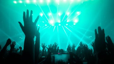Mutlu insanlar gece kulübü DJ parti konserinde dans eder ve sahnede DJ 'den elektronik dans müziği dinlerler. Siluet dolu neşeli kalabalık 2020 yılbaşı partisini kutluyor. İnsanların yaşam tarzı DJ gece hayatı.