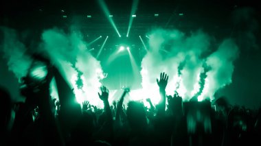Mutlu insanlar gece kulübü DJ parti konserinde dans eder ve sahnede DJ 'den elektronik dans müziği dinlerler. Siluet dolu neşeli kalabalık 2020 yılbaşı partisini kutluyor. İnsanların yaşam tarzı DJ gece hayatı.