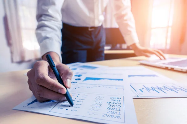 Businessman accountant or financial expert analyze business report graph and finance chart at corporate office. Concept of finance economy, banking business and stock market research.