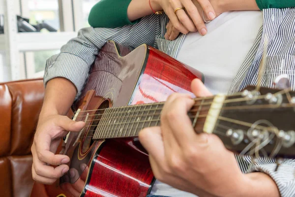 年轻的亚洲夫妇在家里客厅里一起弹奏吉他和唱歌 音乐与生活方式的概念 — 图库照片