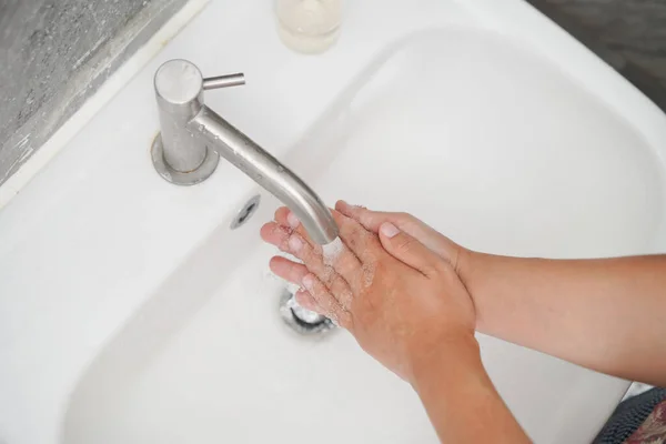 Stock image Hands washing for prevention of novel Coronavirus Disease 2019 or COVID-19 . People wash hands at bathroom sink to clean the virus infection.