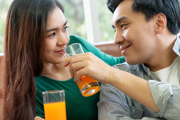 亚洲夫妇在客厅里喝橙汁 健康食品概念 — 图库照片