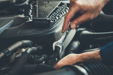 Oto tamirhanesinde araba tamiri ve bakım hizmeti veren profesyonel bir tamirci. Araba servisi iş konsepti.