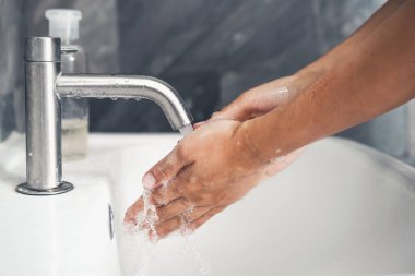 Coronavirus hastalığının önlenmesi için ellerini yıka. 2019 veya COVID-19. İnsanlar virüs enfeksiyonunu temizlemek için lavaboda ellerini yıkıyor..