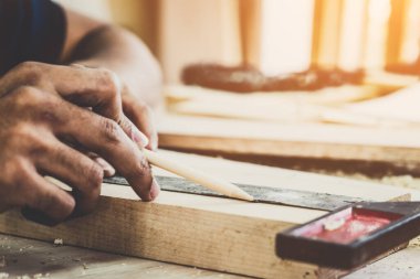 Marangoz atölyede ahşap işçiliği yapıyor. İnşaat malzemesi ya da ahşap mobilya üretiyor. Genç Asyalı marangoz zanaat için profesyonel araçlar kullanır. DIY üreticisi ve marangozluk konsepti.