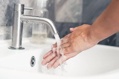 Coronavirus hastalığının önlenmesi için ellerini yıka. 2019 veya COVID-19. İnsanlar virüs enfeksiyonunu temizlemek için lavaboda ellerini yıkıyor..