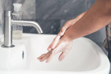 Coronavirus hastalığının önlenmesi için ellerini yıka. 2019 veya COVID-19. İnsanlar virüs enfeksiyonunu temizlemek için lavaboda ellerini yıkıyor..