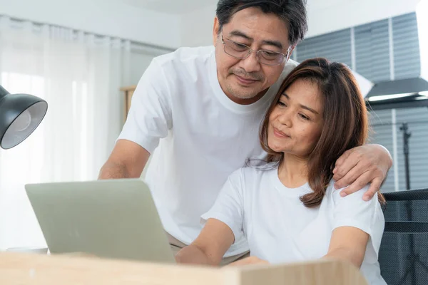 Happy Asian senior couple having good time at home. Old people retirement and healthy citizens elderly concept.