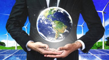Alternatif enerji ile sürdürülebilirlik gelişimi kavramı. Çevre dostu rüzgar türbini çiftliği ve arka planda yeşil yenilenebilir enerji ile insan eliyle dünya ile ilgilenin..