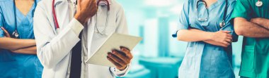 2019 Coronavirus hastalığı ya da COVID-19 ile savaşmak için hastanede çalışan bir doktor. Diğer doktorlar, hemşire ve cerrahlarla birlikte profesyonel sağlık görevlileri. Corona Virüsü Tıbbi Bakım ve Koruma Konsepti.