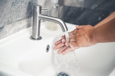 Coronavirus hastalığının önlenmesi için ellerini yıka. 2019 veya COVID-19. İnsanlar virüs enfeksiyonunu temizlemek için lavaboda ellerini yıkıyor..
