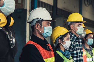 Yüz maskesi olan fabrika işçileri Corona Virüs Hastalığı 2019 veya COVID-19 salgınlarından korunuyor..
