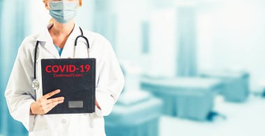 Coronavirus 2019 hastalığı veya COVID-19 küresel salgınından korunmak için hastane maskesi takan bir doktor..