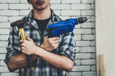 Marangoz atölyede ahşap işçiliği yapıyor. İnşaat malzemesi ya da ahşap mobilya üretiyor. Genç Asyalı marangoz zanaat için profesyonel araçlar kullanır. DIY üreticisi ve marangozluk konsepti.