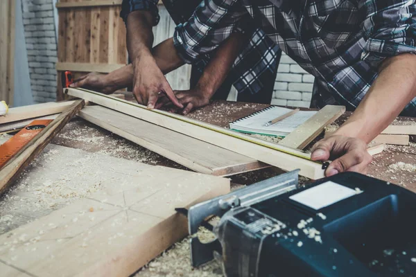 Carpenter working on wood craft at workshop to produce construction material or wooden furniture. The young Asian carpenter use professional tools for crafting. DIY maker and carpentry work concept.