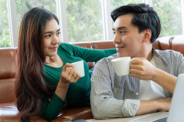 Mutlu Asyalı çift evde kahve içer. Aşk ilişkisi ve yaşam tarzı kavramı.
