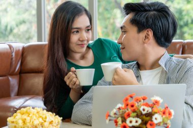 Mutlu Asyalı çift evde kahve içer. Aşk ilişkisi ve yaşam tarzı kavramı.