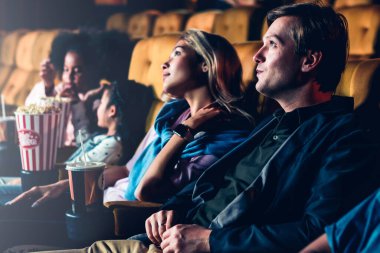 Bir çift ve çocuklar sinemada film izlemekten zevk alıyorlar.