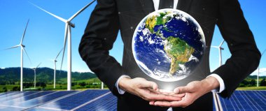 Alternatif enerji ile sürdürülebilirlik gelişimi kavramı. Çevre dostu rüzgar türbini çiftliği ve arka planda yeşil yenilenebilir enerji ile insan eliyle dünya ile ilgilenin..