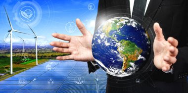 Alternatif enerji ile sürdürülebilirlik gelişimi kavramı. Çevre dostu rüzgar türbini çiftliği ve arka planda yeşil yenilenebilir enerji ile insan eliyle dünya ile ilgilenin..