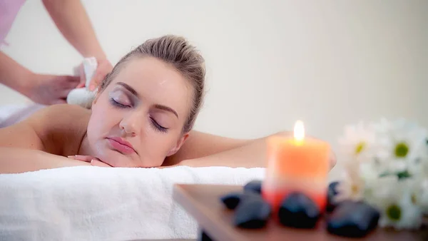 Massagetherapeut Houdt Een Kruidenkompres Een Behandeling Doen Voor Een Vrouw — Stockfoto