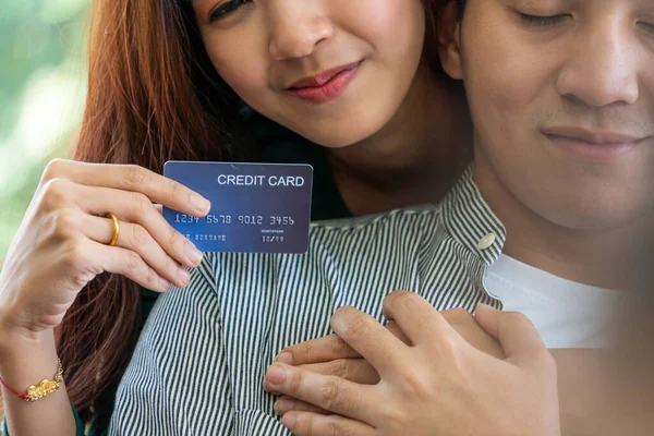 Young couple use credit card for online shopping on internet website at home. Number on the credit card is mock up. No personal information shown on the credit card. Online business shopping concept.