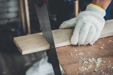 Marangoz atölyede ahşap işçiliği yapıyor. İnşaat malzemesi ya da ahşap mobilya üretiyor. Genç Asyalı marangoz zanaat için profesyonel araçlar kullanır. DIY üreticisi ve marangozluk konsepti.