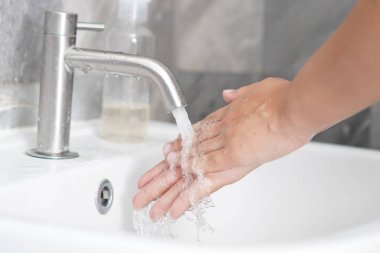 Coronavirus hastalığının önlenmesi için ellerini yıka. 2019 veya COVID-19. İnsanlar virüs enfeksiyonunu temizlemek için lavaboda ellerini yıkıyor..