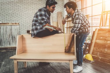 Marangoz atölyede ahşap işçiliği yapıyor. İnşaat malzemesi ya da ahşap mobilya üretiyor. Genç Asyalı marangoz zanaat için profesyonel araçlar kullanır. DIY üreticisi ve marangozluk konsepti.