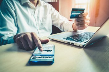 Genç adam, laptop bilgisayar başvurusu ya da web sitesinde online alışveriş yapmak için kredi kartı kullanıyor. E-ticaret ve online alışveriş kavramı.