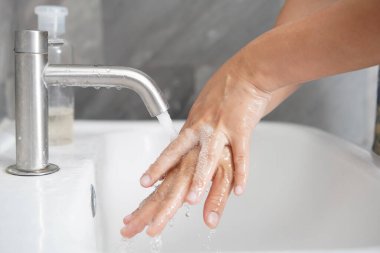 Coronavirus hastalığının önlenmesi için ellerini yıka. 2019 veya COVID-19. İnsanlar virüs enfeksiyonunu temizlemek için lavaboda ellerini yıkıyor..