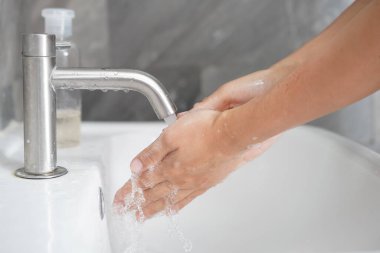 Coronavirus hastalığının önlenmesi için ellerini yıka. 2019 veya COVID-19. İnsanlar virüs enfeksiyonunu temizlemek için lavaboda ellerini yıkıyor..