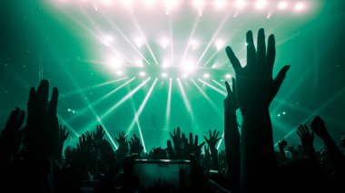 Mutlu insanlar gece kulübü DJ parti konserinde dans eder ve sahnede DJ 'den elektronik dans müziği dinlerler. Siluet dolu neşeli kalabalık 2020 yılbaşı partisini kutluyor. İnsanların yaşam tarzı DJ gece hayatı.