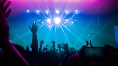 Mutlu insanlar gece kulübü DJ parti konserinde dans eder ve sahnede DJ 'den elektronik dans müziği dinlerler. Siluet dolu neşeli kalabalık 2020 yılbaşı partisini kutluyor. İnsanların yaşam tarzı DJ gece hayatı.