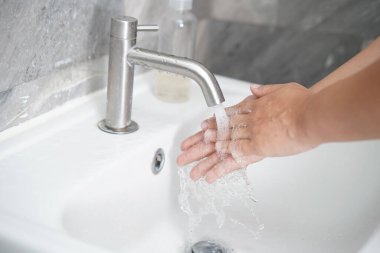 Coronavirus hastalığının önlenmesi için ellerini yıka. 2019 veya COVID-19. İnsanlar virüs enfeksiyonunu temizlemek için lavaboda ellerini yıkıyor..