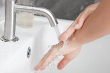 Coronavirus hastalığının önlenmesi için ellerini yıka. 2019 veya COVID-19. İnsanlar virüs enfeksiyonunu temizlemek için lavaboda ellerini yıkıyor..