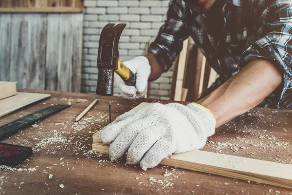 Marangoz atölyede ahşap işçiliği yapıyor. İnşaat malzemesi ya da ahşap mobilya üretiyor. Genç Asyalı marangoz zanaat için profesyonel araçlar kullanır. DIY üreticisi ve marangozluk konsepti.