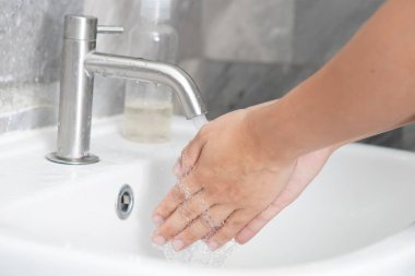 Coronavirus hastalığının önlenmesi için ellerini yıka. 2019 veya COVID-19. İnsanlar virüs enfeksiyonunu temizlemek için lavaboda ellerini yıkıyor..