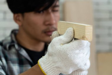 Marangoz atölyede ahşap işçiliği yapıyor. İnşaat malzemesi ya da ahşap mobilya üretiyor. Genç Asyalı marangoz zanaat için profesyonel araçlar kullanır. DIY üreticisi ve marangozluk konsepti.