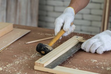 Marangoz atölyede ahşap işçiliği yapıyor. İnşaat malzemesi ya da ahşap mobilya üretiyor. Genç Asyalı marangoz zanaat için profesyonel araçlar kullanır. DIY üreticisi ve marangozluk konsepti.