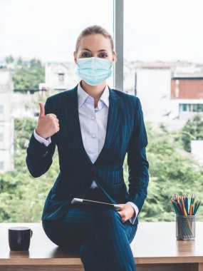 Coronavirus veya COVID-19 yüzünden yüz maskesi olan bir ofis çalışanı. Coronavirus veya COVID-19 'un yayılmasını engellemek ve işletmeyi yeniden açmak için koruyucu çalışma ortamı kavramı.