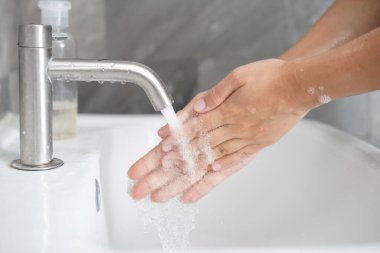 Coronavirus hastalığının önlenmesi için ellerini yıka. 2019 veya COVID-19. İnsanlar virüs enfeksiyonunu temizlemek için lavaboda ellerini yıkıyor..