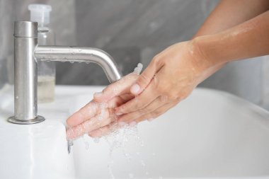 Coronavirus hastalığının önlenmesi için ellerini yıka. 2019 veya COVID-19. İnsanlar virüs enfeksiyonunu temizlemek için lavaboda ellerini yıkıyor..